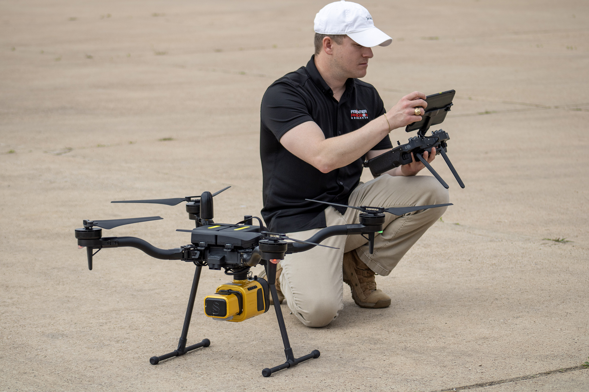 A person is working on a drone before it takes off from the ground.